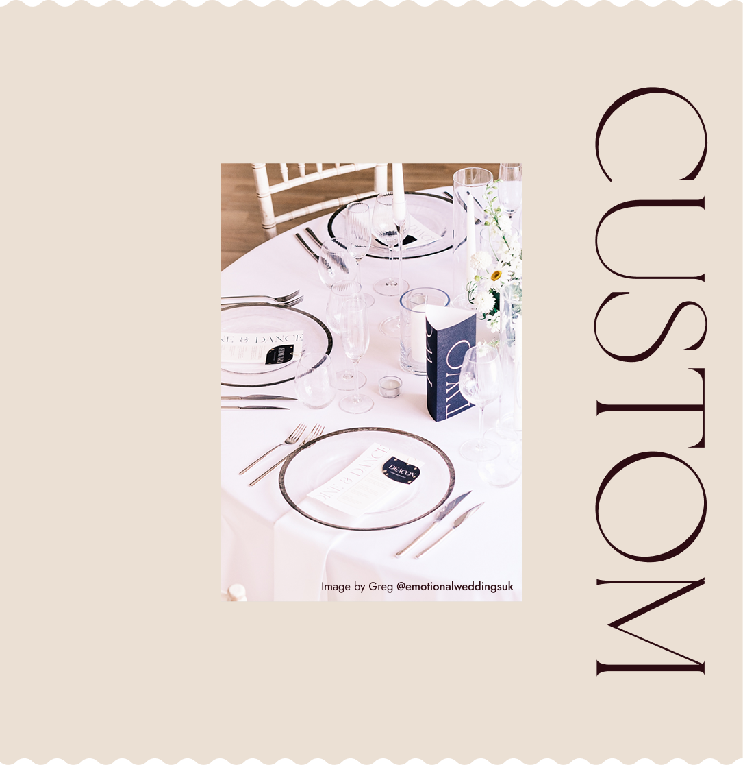 Wedding table stationery with white cards, place settings, glassware and floral details, styled in soft neutral tones
