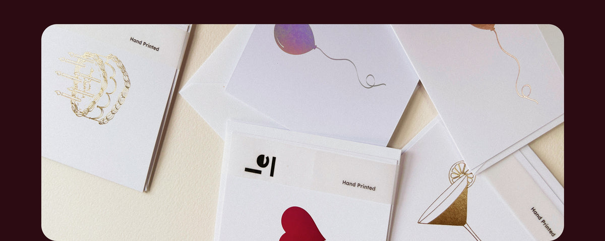 Foil printed wedding stationery cards with gold and red details, envelopes and textured paper arranged together